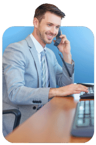 An employee of Ramsden & Whale Limited, sat at an office desk and wearing a suit, answering a "contact us" telephone call to a new potential customer.