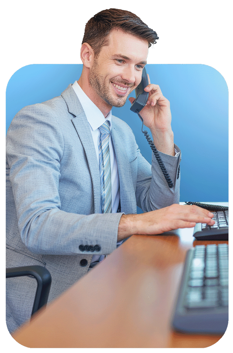 An employee of Ramsden & Whale Limited, sat at an office desk and wearing a suit, answering a "contact us" telephone call to a new potential customer.