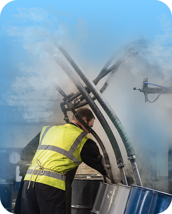 An operative inserting lances into a 205 litre steel drum, to steam-dry the insides of the drum, as part of an industrial reconditioning process, one of the services that Ramsden Drums provide.